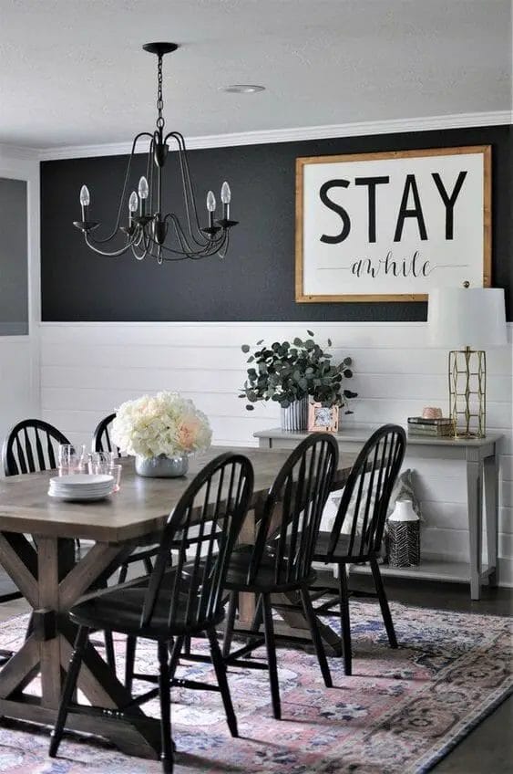 Photo of a farmhouse dining room design with a big sign hang on the wall.